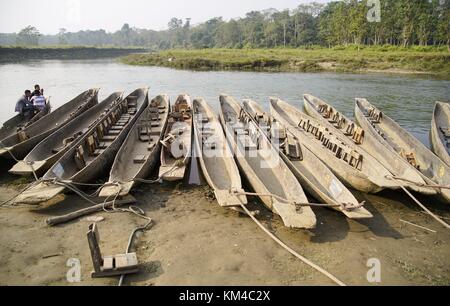 Solche langen Boote (Dugouts) sind das übliche Transportmittel auf dem Narayani River im Chitwan National Park. Sie werden mit Stangen nach vorn bewegt. (26. November 2016) | Nutzung weltweit Stockfoto