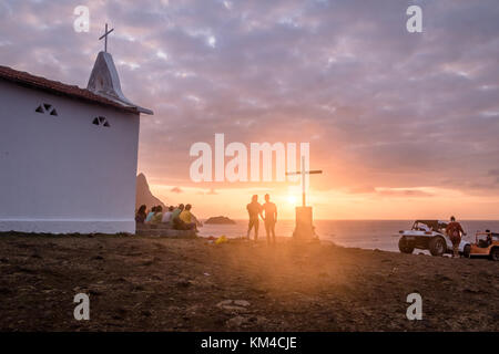 Leute, die sich den Sonnenuntergang an der Kapelle von Sao Pedro dos Pescadores - Fernando de Noronha, Pernambuco, Brasilien Stockfoto