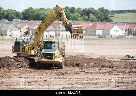 Haus Gebäude auf einer Brachfläche im Bishopton, Schottland zeigt neue Häuser, gerodeten Flächen und Bagger den Boden bereiten Stockfoto