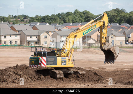 Haus Gebäude auf einer Brachfläche im Bishopton, Schottland zeigt neue Häuser, gerodeten Flächen und Bagger den Boden bereiten Stockfoto