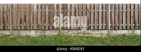 Lange alte Feste im Alter von braun Holz- ländlichen Zaun von der vertikalen Kiefer Planken. base von cimple Beton. auf weißem Panoramablick collage isoliert Stockfoto
