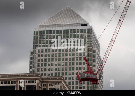 Ein Baustellenkran am Bau, der vom riesigen Turm von One Canada Square, Canary Wharf, Docklands, London, Großbritannien übersehen wird Stockfoto