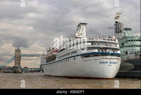 HMS Belfast mit dem Kreuzfahrtschiff MV Ocean Majesty festgemacht an der Seite in den Pool von London, Tower Bridge im Hintergrund Stockfoto