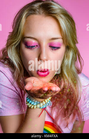 Schöne blonde Mädchen im Teenageralter auf rosa Hintergrund. Rosa themed Serie. Stockfoto