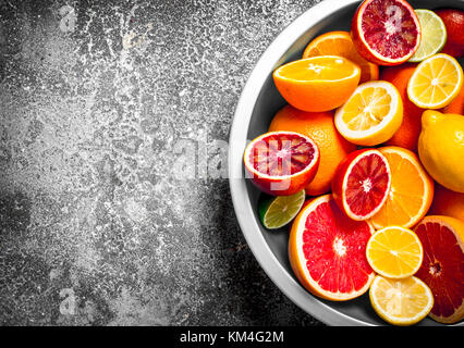Aufgeschnittene Zitrusfrüchte in eine große Schüssel geben. Auf rustikalen Hintergrund. Stockfoto