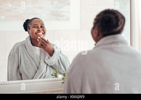 Lächelnd afrikanische Frau in ihrem Badezimmer Spiegel Stockfoto