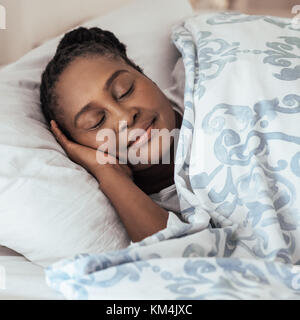 Reifen afrikanische Frau fest schlafend in ihrem Bett zu Hause. Stockfoto