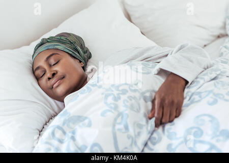 Junge afrikanische Frau in ihrem Bett schläft liegend Stockfoto