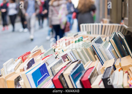 Bunte alte Second Hand Bücher Anzeige auf Stativ, in einer Straße von Neapel, Italien. Unscharfe Leute, Shopping im Hintergrund. Stockfoto