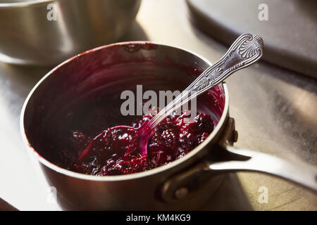 Hohe Betrachtungswinkel von Rote Grütze in eine Kasserolle mit einem silbernen Löffel. Stockfoto