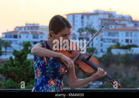 Eine schöne junge Dame Spielen der Violine am Balcon de Europa in Nerja an der Costa del Sol in Spanien Stockfoto