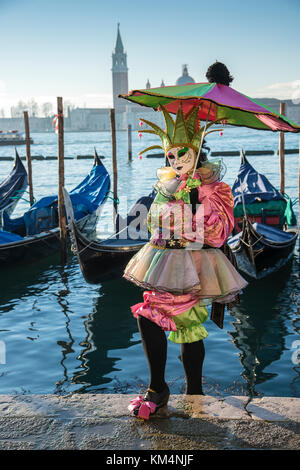 Kostümierte Venezianischen vor der Gondeln in St. Mark's Square während des Karnevals in Venedig, Italien. Stockfoto