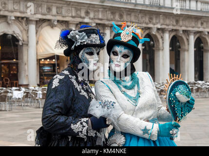 Zwei Frauen im Kostüm für den Karneval in St. Markusplatz in Venedig, Italien, gekleidet. Stockfoto