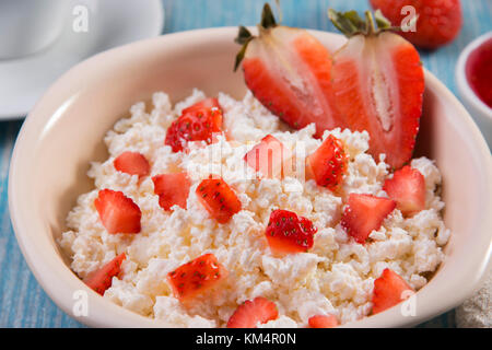 Hüttenkäse körnig Krümelig mit Stücken von Erdbeeren Konfitüre und Kaffee Frühstück Stockfoto