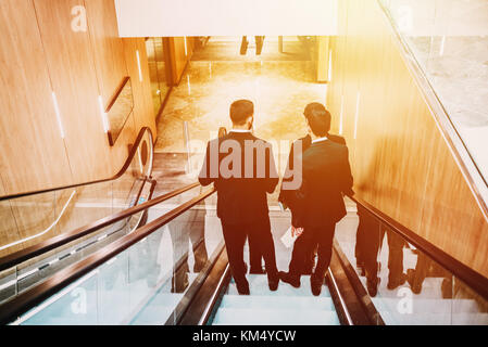 4 Männer im Anzug im Einkaufszentrum oder buisnes Center. Stockfoto