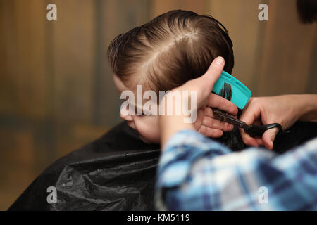 Ein kleiner Junge ist in hellen die Emotionen der Friseur auf getrimmt Stockfoto