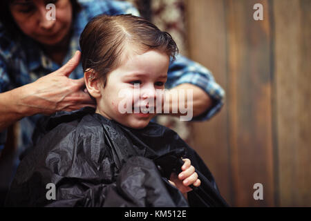 Ein kleiner Junge ist in der Friseur getrimmt Stockfoto