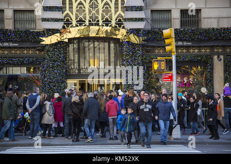 Massen von Menschen einkaufen und Anzeigen Weihnachten windows bei Saks Fifth Avenue auf der 5th Avenue zu Beginn der Saison am Schwarzen Freitag, Wochenende nach Thanksgiving in New York City. Stockfoto