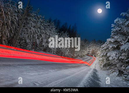 Leichte Spuren von Auto auf einer Landstrasse bei Nacht Stockfoto