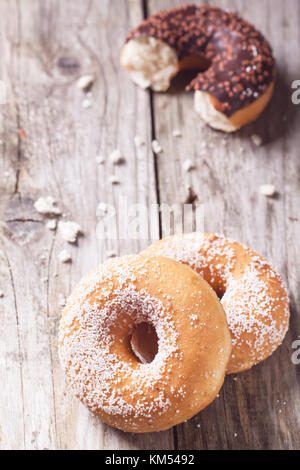Zucker Donuts und die Hälfte der Schokolade Donut serviert auf Holztisch. siehe Serie Stockfoto
