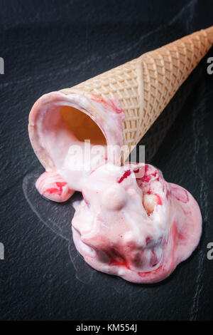 Wafer Kegel mit Erdbeereis auf schwarzem Glas. Stockfoto