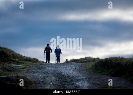 Paar mittleren Alters und ihrem Hund das Gehen an einem kalten Wintertag. stanage Edge, Derbyshire, England. Stockfoto