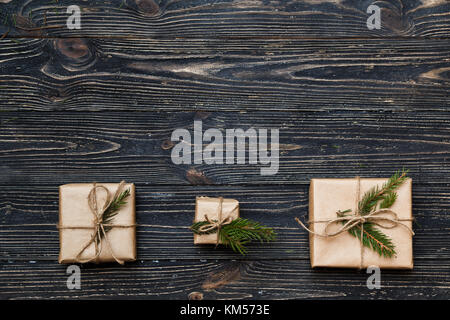 Drei Vintage Geschenkboxen mit Fichte Äste auf hölzernen Hintergrund mit Kopie Raum Stockfoto