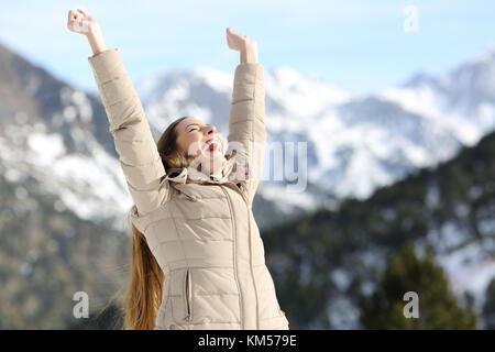 Aufgeregt Frau Anheben der Arme Erfolg feiern in die schneebedeckten Berge im Winter Stockfoto