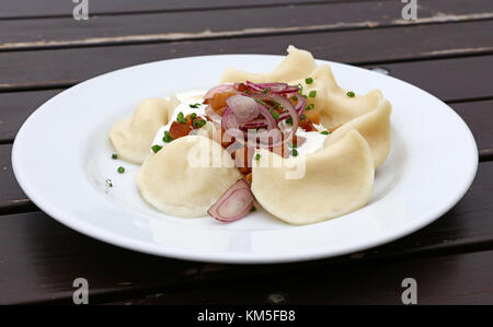 Platte von PIEROGI oder Wareniki gefüllte Teigtaschen gefüllt mit saurer Sahne, Speck und Zwiebel, traditionelle ost europa Küche beliebt in Polen, Ukrain Stockfoto