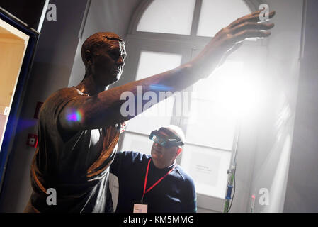 Karlsruhe, Deutschland. Dezember 2017. Mario Iozzo, Direktor des Nationalen Archäologischen Museums von Florenz, überprüft die lebensgroße Bronzestatue des etruskischen Avle Metele aus dem 2. Bis 1. Jahrhundert v. Chr. im Staatlichen Museum Baden-Württemberg auf Schloss Karlsurhe in Karlsruhe, Deutschland, 4. Dezember 2017. Die Statue stammt aus dem Nationalen Archäologischen Museum von Florenz und ist Teil der Ausstellung „die Etrusker - Weltkultur im alten Italien“, die vom 16. Dezember 2017 bis 17. Juni 2017 in Karslruhe für Besucher geöffnet wird. Quelle: Uli Deck/dpa/Alamy Live News Stockfoto