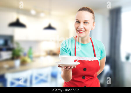 Hausfrau oder Hausmädchen mit einer Tasse Kaffee am Morgen oder Nachmittag Tee auf Home Küche Hintergrund Stockfoto