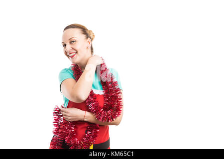 Glückliche Ehefrau tanzen trägt einen roten Schürze und lametta oder girlande auf weißem Hintergrund Stockfoto