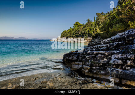 In der Nähe von Strand und Kalkfelsen und liegt in einer kleinen ruhigen Bucht auf der Strecke und in der Nähe der das Dorf Fiskardo das türkisfarbene Meer in der Stockfoto