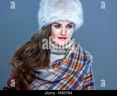 Wintersachen. Porträt von nachdenklich trendige Frau in Pelzmütze isoliert auf kalten Blau Stockfoto