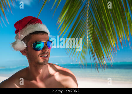 Touristische Mann mit Santa Claus hat sich auf tropische Insel Strand Punta Cana, Dominikanische Republik. Stockfoto