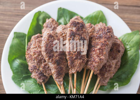 Rindfleisch cabobs auf die frische Spinatblätter Stockfoto