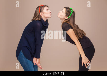 Spielerisch Schwestern Küsse und geschlossenen Augen. Liebe, Familie. indoor Schuß Stockfoto