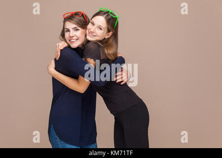 Glück Schwestern umarmen und toothy Lächeln. studio Shot Stockfoto