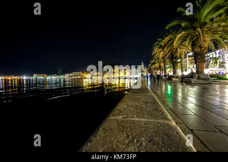 Split Hafen und die Uferpromenade Riva spät in der Nacht mit Palmen und Lichter reflektiert die Adria. Stockfoto
