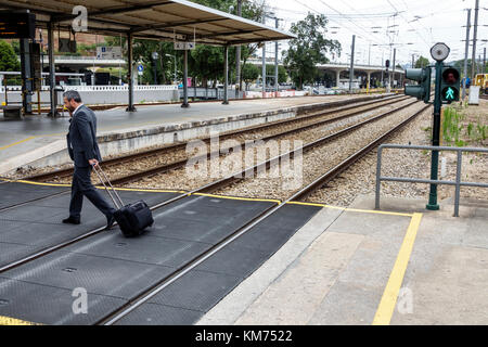 Coimbra Portugal, Coimbra B, Comboios de Portugal, Eisenbahn, Zug, Bahnhof, Strecke, Linie, Plattform, Mann Männer männlich, Geschäftsmann, rollendes Gepäck, Bahnübergang, Pedal Stockfoto