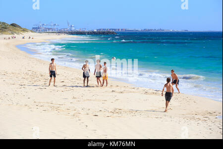 Teenager Jungs spielen Fußball auf Cottesloe Beach in Perth, Western Australia Stockfoto