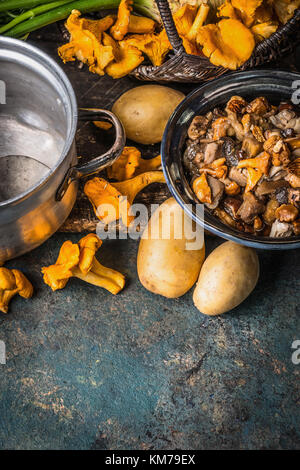 Verschiedene Wald Pilze mit Kartoffel auf rustikale Küche Tisch Hintergrund, Ansicht von oben, Platz für Text. saisonale Herbst kochen Konzept Stockfoto