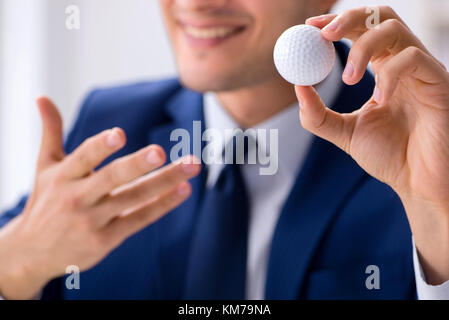 Junge Unternehmer mit Golf ball Arbeiten im Büro Stockfoto
