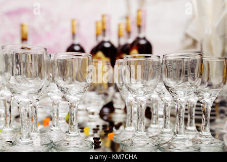 Gläser auf Spiegelfläche vor dem Hintergrund von Flaschen Brandy Stockfoto