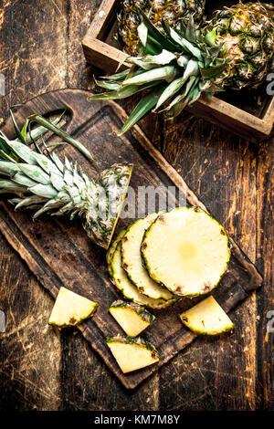 In Scheiben geschnittene frische Ananas. Auf dem hölzernen Hintergrund. Stockfoto