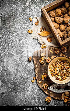 Ohne Schale Walnüsse in der Schale mit Nussknacker. Auf rustikalen Hintergrund. Stockfoto