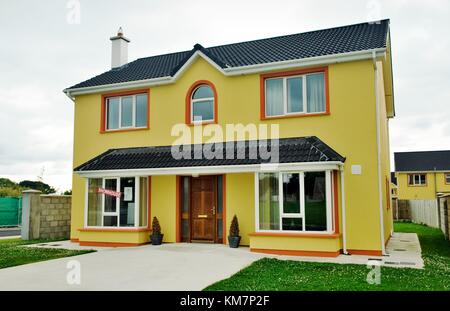 Neu errichtete freistehende Einfamilienhäuser in der Wohnsiedlung Entwicklung im Dorf Abbeydorn, County Kerry, Irland. Für den Verkauf. Stockfoto