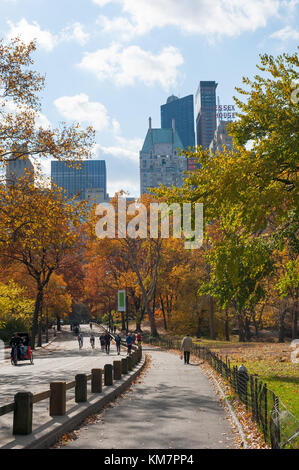 New York City, USA - 11.11.2011: Menschen zu Fuß im Central Park im Herbst mit Manhattan Gebäude im Hintergrund Stockfoto