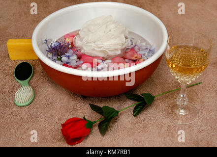 Schale mit Blütenblätter schweben im Wasser und Bad-Accessoires Stockfoto