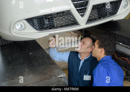 Mechanik prüfen der technischen Stand unter einem Auto Stockfoto